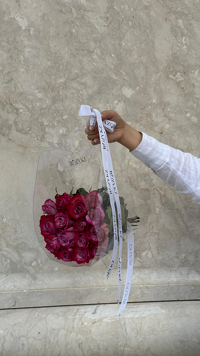 15 purple roses in a transparent bag