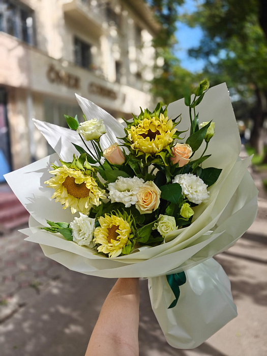 Средний асимметричный букет из желтых подсолнухов, белых роз и эустом с листвой в белой и молочной матовой пленке - купить в Астане с доставкой